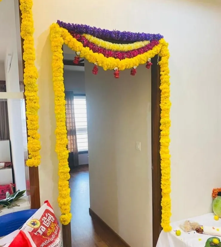 Fresh marigold flower setup around bedroom door during gruhapravesha ceremony in Bangalore
