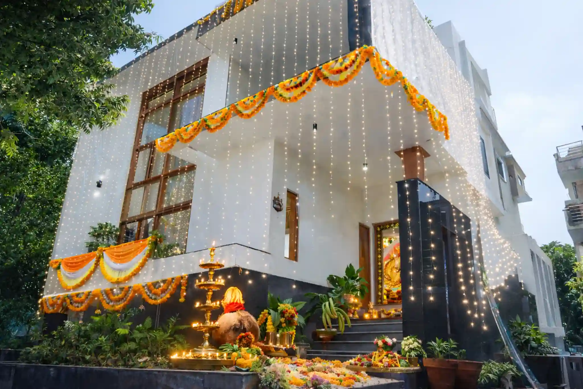 House decorated with lights and flowers for house warming ceremony in Bangalore with pooja setup and entrance decor